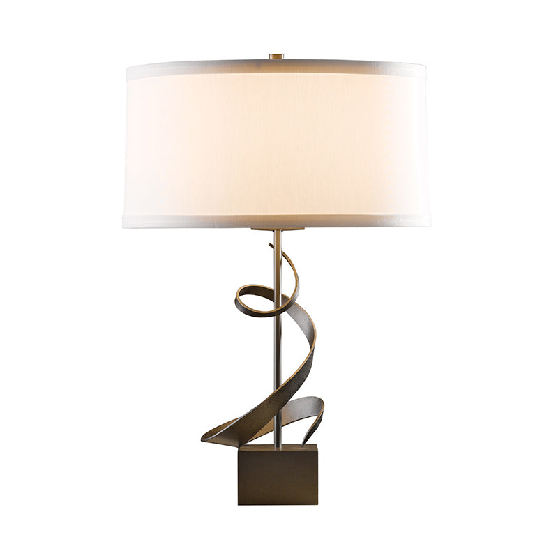 Gallery Spiral Table Lamp by Hubbardton Forge with burnished steel ribbon base and white drum shade; American-made, high quality craftsmanship.