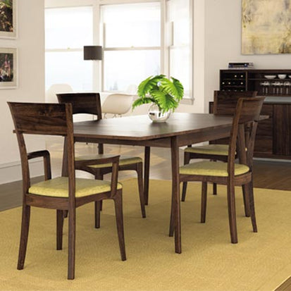 A dining room with a wooden table and chairs.