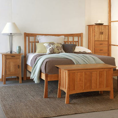 A bedroom with a bed, dresser and nightstand.