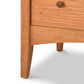Close-up of a handcrafted solid wood cabinet from Maple Corner Woodworks' American Shaker 5-Drawer Chest featuring a visible drawer with a round knob.