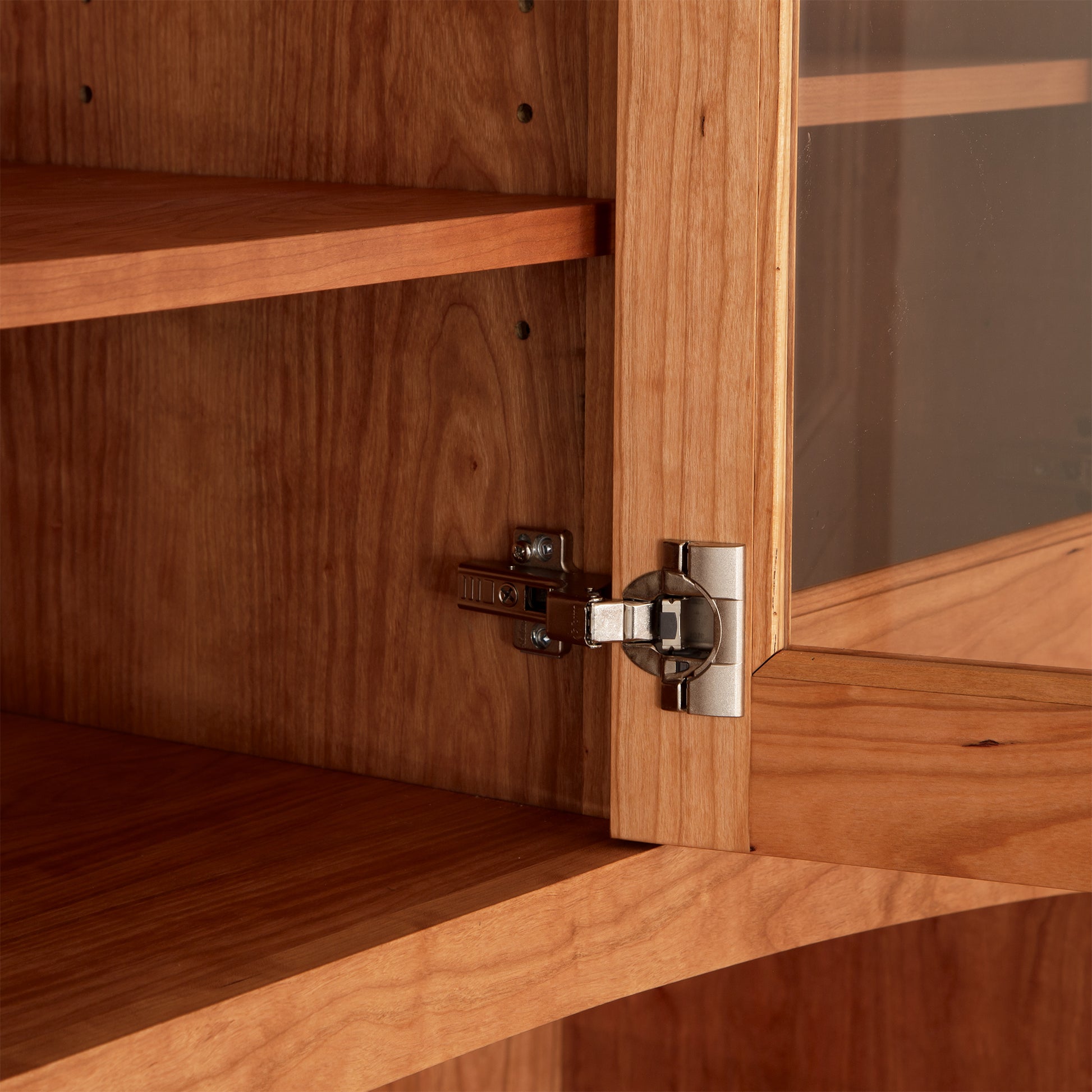 American Shaker 50" China Cabinet by Maple Corner Woodworks, featuring classic Vermont craftsmanship, partially open glass door, metal hinges, and two empty solid hardwood shelves.