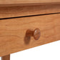 Wooden drawer with round wooden knob on light wood cabinet, inspired by the American Shaker Writing Desk, expertly crafted by Vermont artisans from sustainably harvested hardwood.