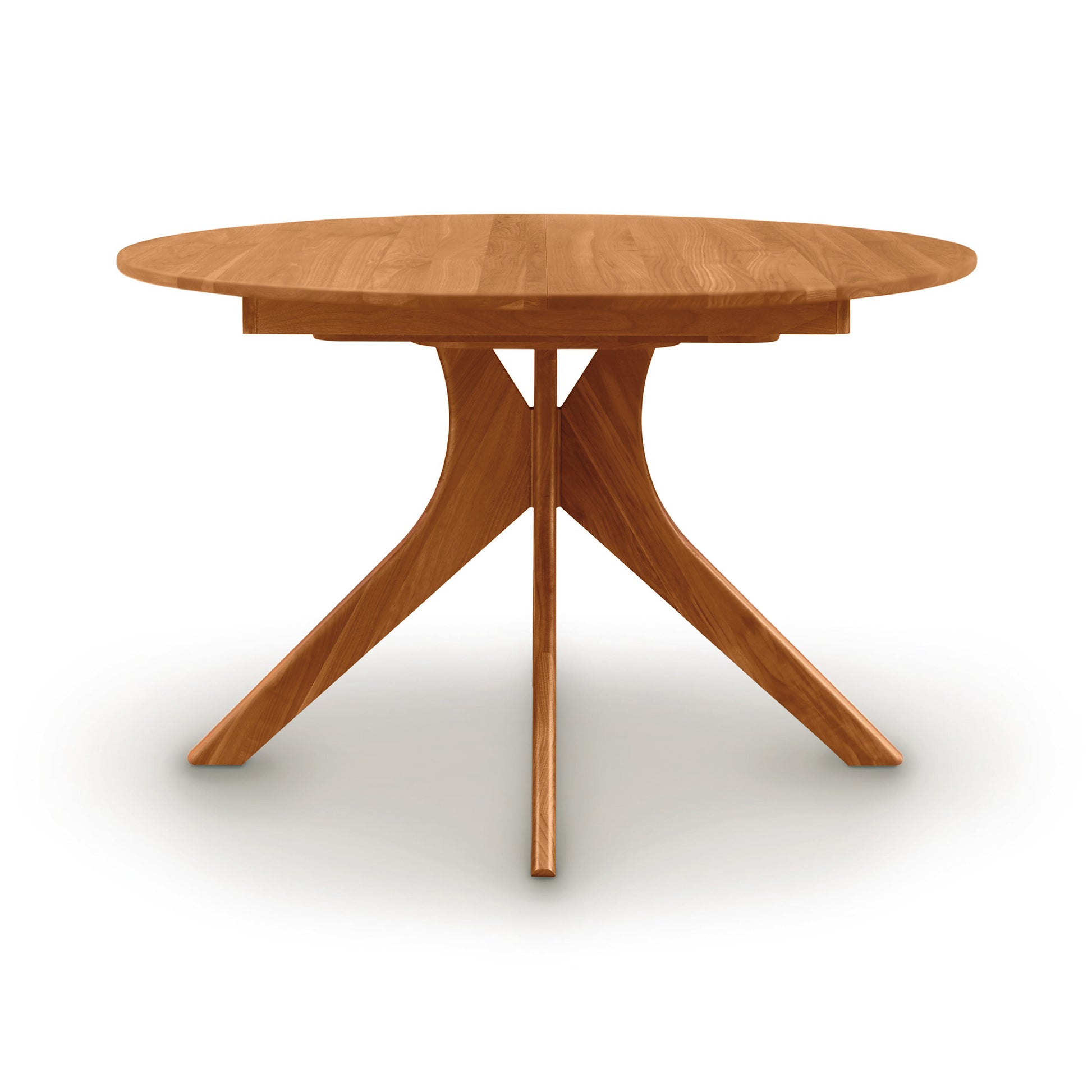 Audrey Round Extension Dining Table by Copeland Furniture with a solid wood top and distinctive geometric base, showcasing elegant American craftsmanship.