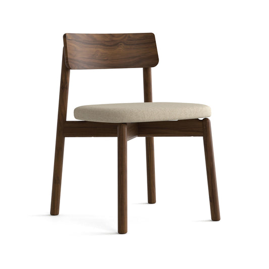 Baton Chair by Copeland Furniture with a curved backrest and beige cushion, highlighting its elegant design and craftsmanship.