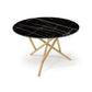 Baton Round Sintered Stone Top Table by Copeland Furniture with a black marble top and light wood crisscross legs, crafted in Vermont.