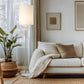 White sofa with beige pillows and the Hubbardton Forge Cairn Floor Lamp, showcasing American made living room furniture.