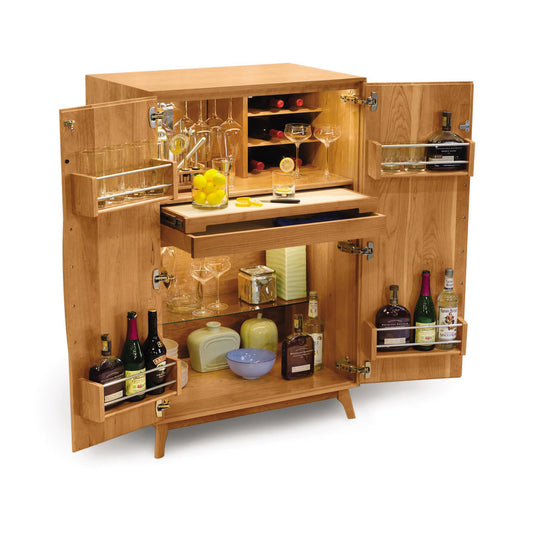 Catalina Bar Cabinet by Copeland Furniture shown with open doors, highlighting its spacious shelves and wine storage. Glassware and bottles displayed inside.