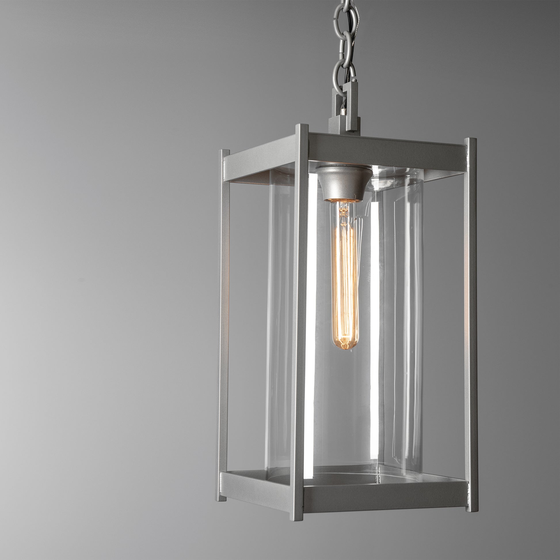 Cela Large Outdoor Lantern by Hubbardton Forge with clear glass panels, steel frame, and exposed bulb design hanging from a sturdy chain.