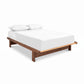 Cherry Moon Dovetail Platform Bed by Maple Corner Woodworks showcases fine craftsmanship and dovetail joinery, highlighted with simple white bedding.