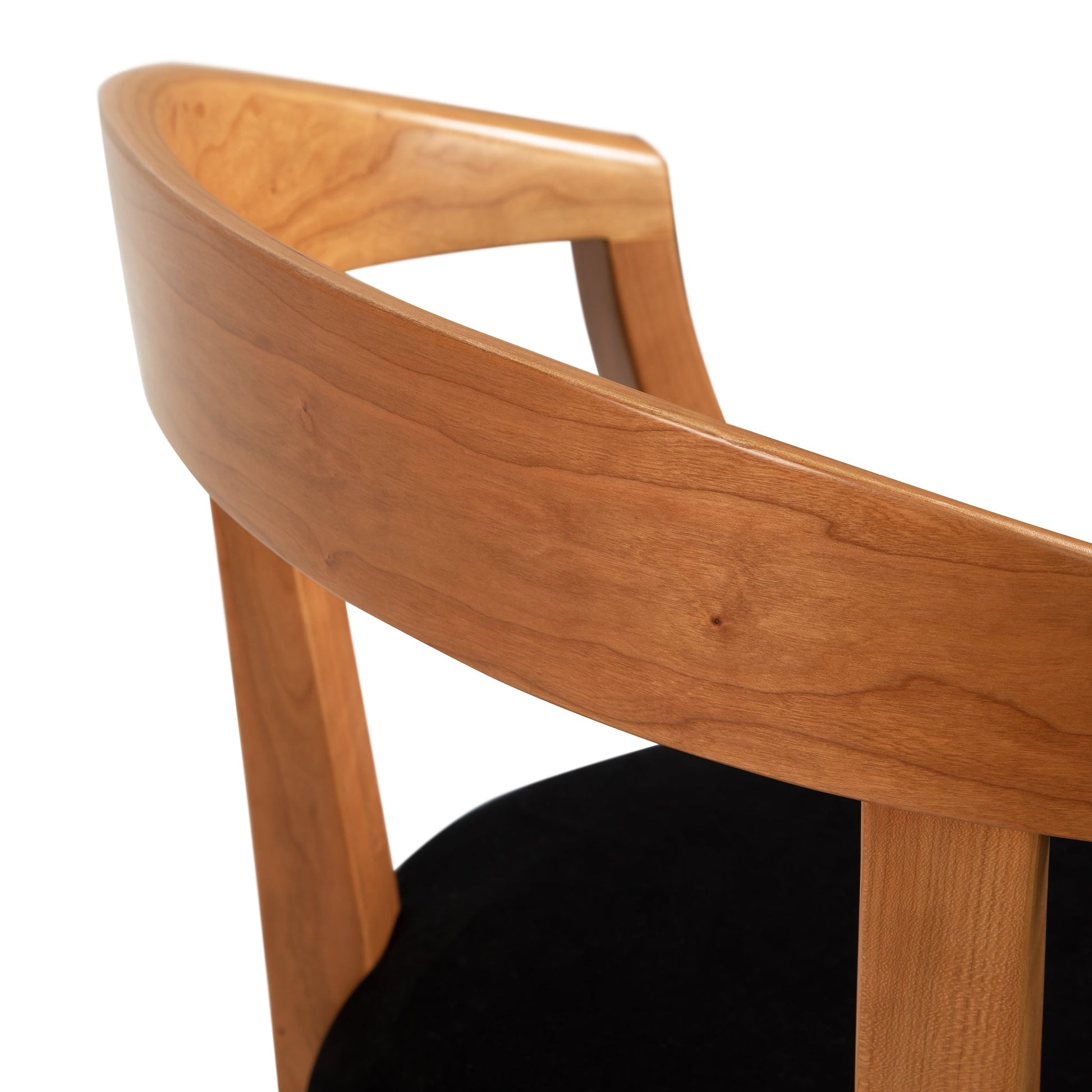 Dorset Chair by Vermont Woods Studios with black upholstered cushioned seat and curved backrest, highlighting its elegant craftsmanship.