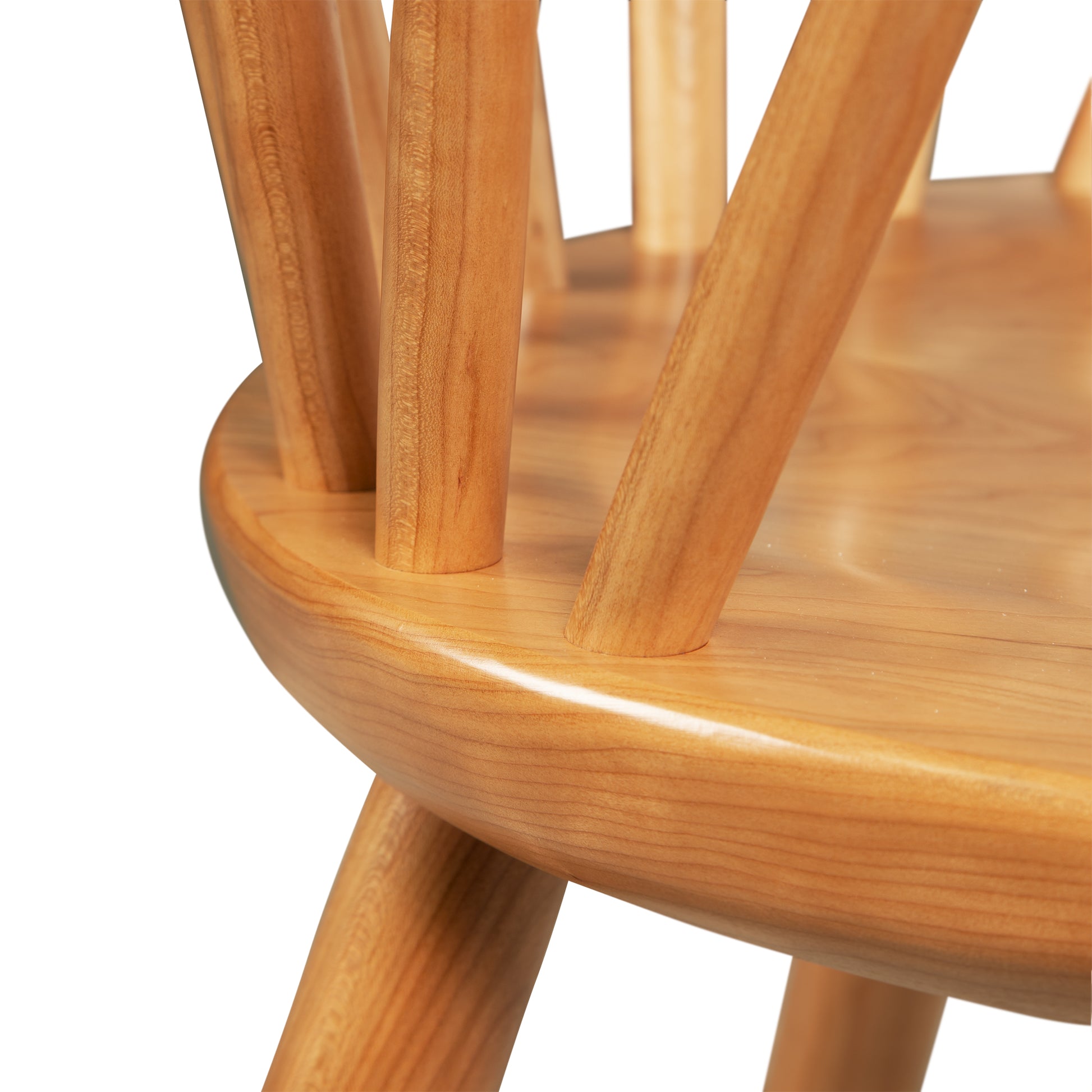 Vermont Woods Studios Dover Curveback Windsor Chair in Cherry, highlighting the smooth seat and vertical backrest spindles, expertly crafted.