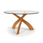 Copeland Furniture Entwine round dining table with a cherry wood sculpted base and clear glass top, modern design highlighted against a neutral background.