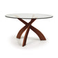 Entwine Round Glass Top Dining Table by Copeland Furniture with three intersecting cherry wood legs, highlighting elegant craftsmanship.