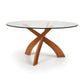 Entwine Round Glass Top Dining Table by Copeland Furniture with a sculptural cherry wood base, highlighting its elegant craftsmanship.