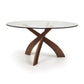Entwine Round Glass Top Dining Table by Copeland Furniture with three intersecting cherry wood legs and a sleek, circular tempered glass top.