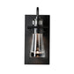 Close-up of the Hubbardton Forge Erlenmeyer Medium Outdoor Sconce in black metal and clear glass, crafted in Vermont for quality American-made outdoor lighting.