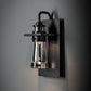Hubbardton Forge Erlenmeyer Medium Outdoor Sconce with black base and clear glass shade, handcrafted American lighting accent for outdoor spaces.