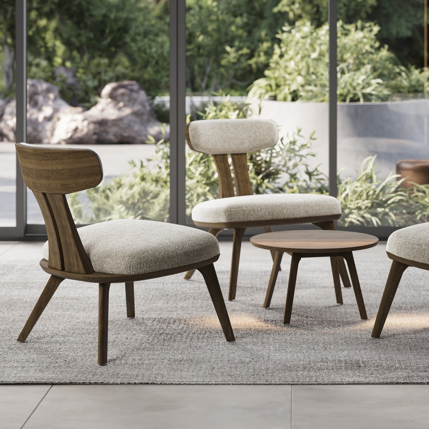 Handcrafted Copeland Furniture Estelle Lounge Chairs with cushions and a round table displayed on a textured rug, showcasing premium American craftsmanship.