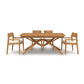 Exeter Extension Dining Table by Copeland Furniture with a distinctive X-shaped base and matching chairs featuring white cushions, crafted from North American hardwood.