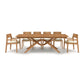 Exeter Extension Dining Table by Copeland Furniture featuring a distinctive wooden X-shaped base, complemented by six cushioned chairs and a convenient butterfly leaf extension.