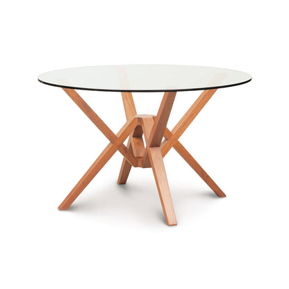 Exeter Round Glass Top Table by Copeland Furniture with geometric hardwood base, highlighting the modern craftsmanship and elegant design.