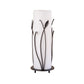Tall cylindrical Hubbardton Forge Table Lamp with forged leaves, featuring a bronze frame and a round base with three legs.