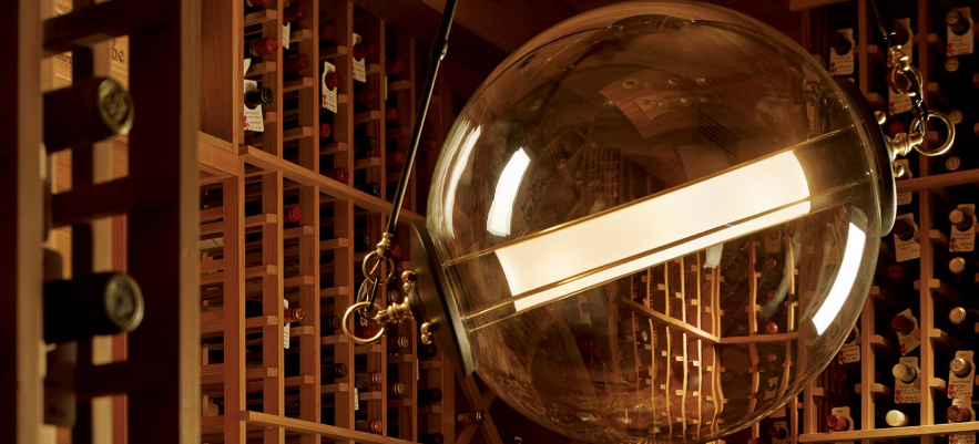 A wine cellar with many bottles of wine hanging from the ceiling.