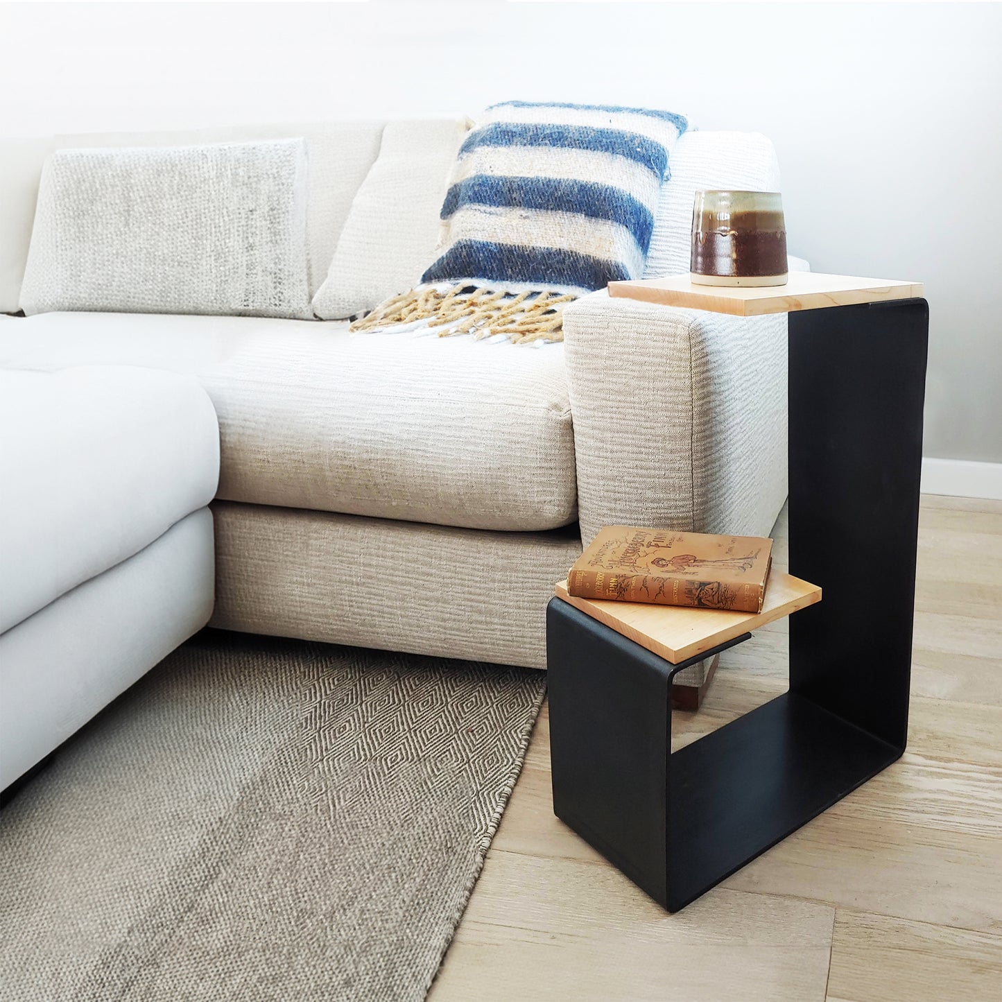 Vermont Woods Studios G Table crafted from natural hardwood, shown close-up with a book and glass for scale.