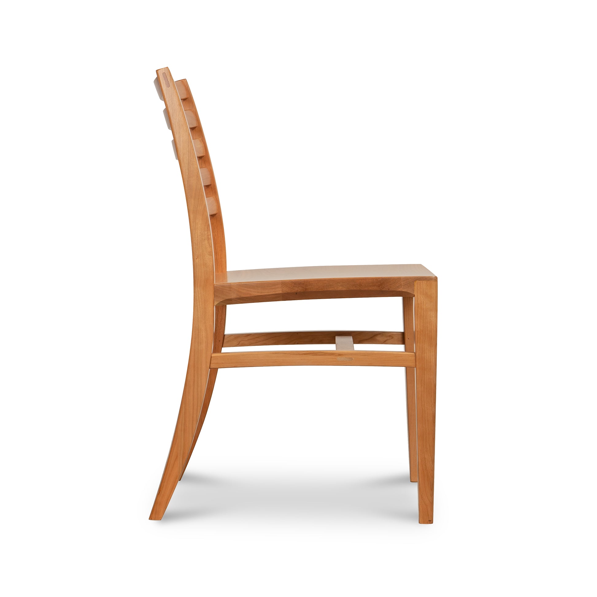 Vermont Woods Studios Grafton Chair in natural wood, shown from the side with a straight seat, curved backrest, and four sturdy rectangular legs.