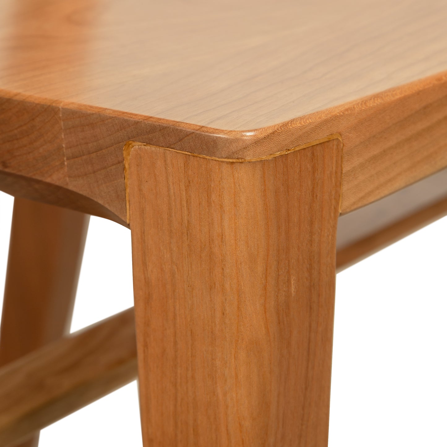 Close-up of Grafton Chair by Vermont Woods Studios, focusing on the cherry wood leg-to-seat joint and expertly crafted, smooth grain.