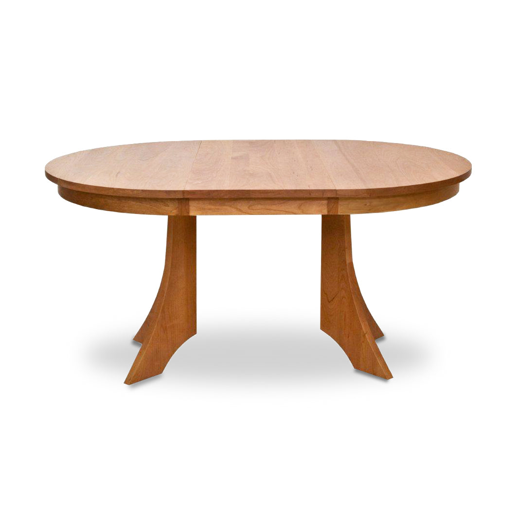 Hampton Split Pedestal Extension Table by Lyndon Furniture showcasing an oval wood top with two graceful curved pedestal bases.