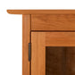 Detail view of the Heartwood Shaker 2-Glass Door Bookcase by Vermont Furniture Designs, highlighting the handcrafted wood, hinge, and glass door panel.
