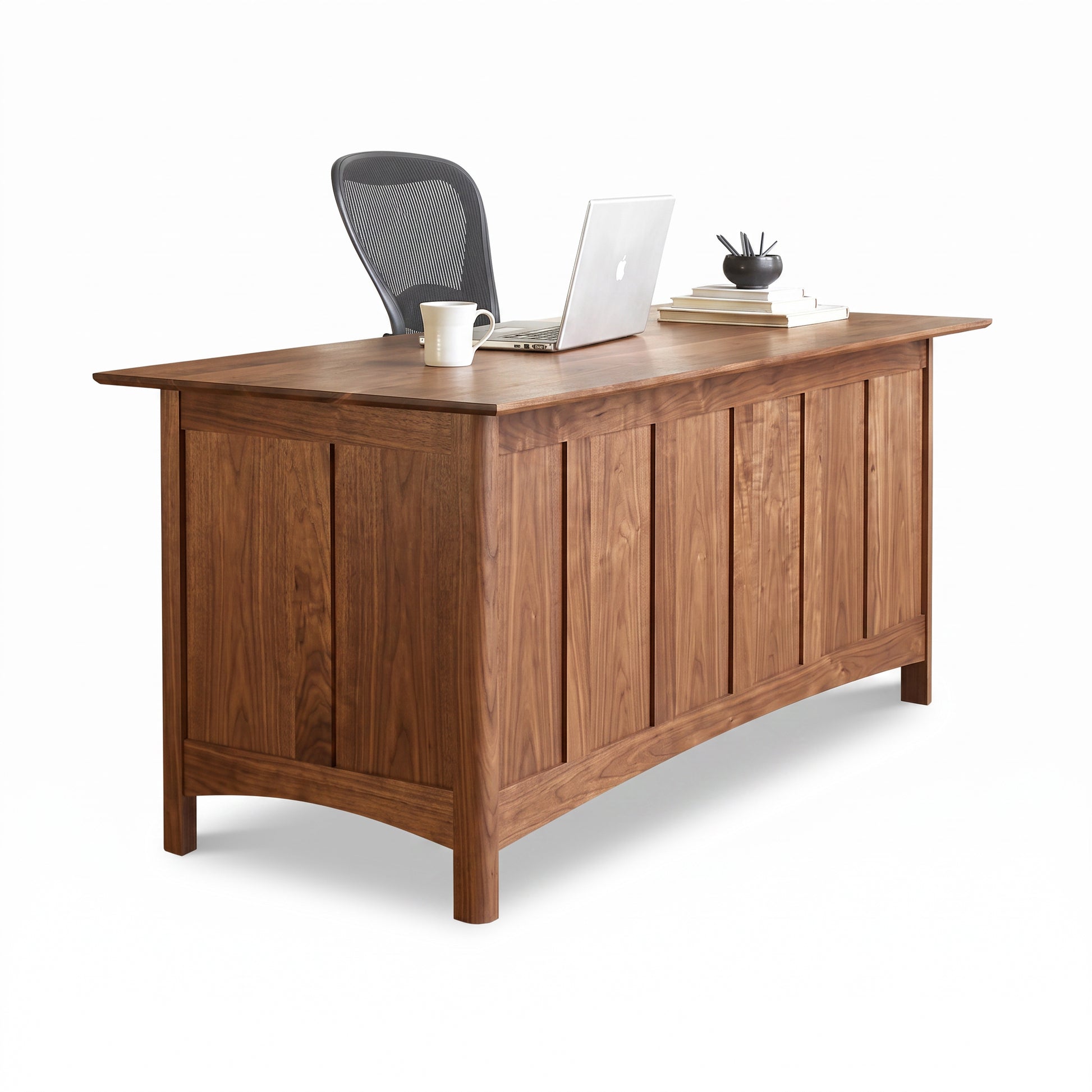 Heartwood Shaker Executive Desk by Vermont Furniture Designs features classic craftsmanship and is paired with a chair, laptop, and books.