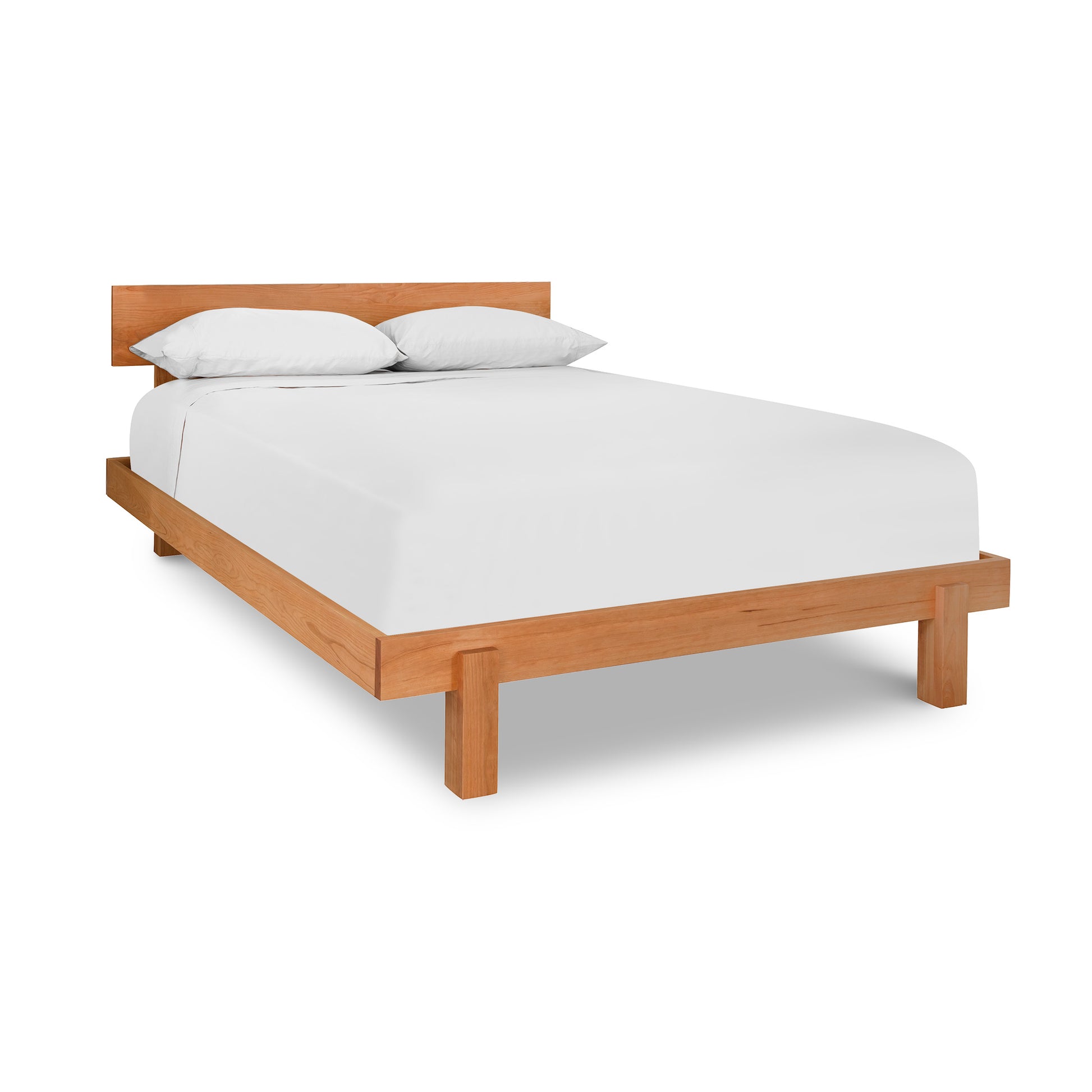 Kipling Bed with a solid wood frame by Vermont Furniture Designs, showcasing a white mattress and two pillows.