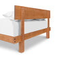 Solid wood Kipling Bed with plush mattress and white bedding, viewed from the footboard by Vermont Furniture Designs.