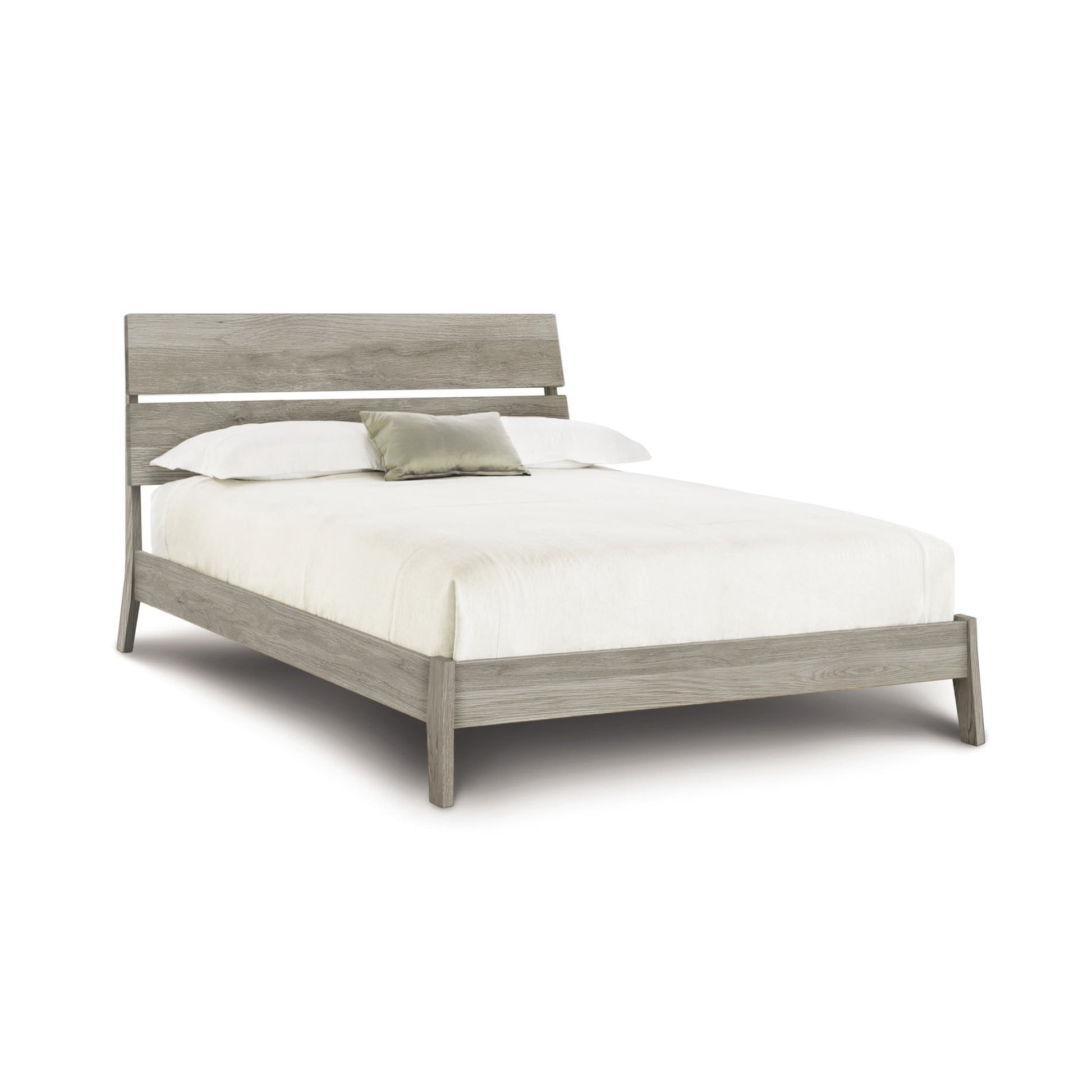 Linn Platform Bed by Copeland Furniture, featuring a light gray wooden frame and ergonomic headboard, complemented by white bedding and a gray cushion.