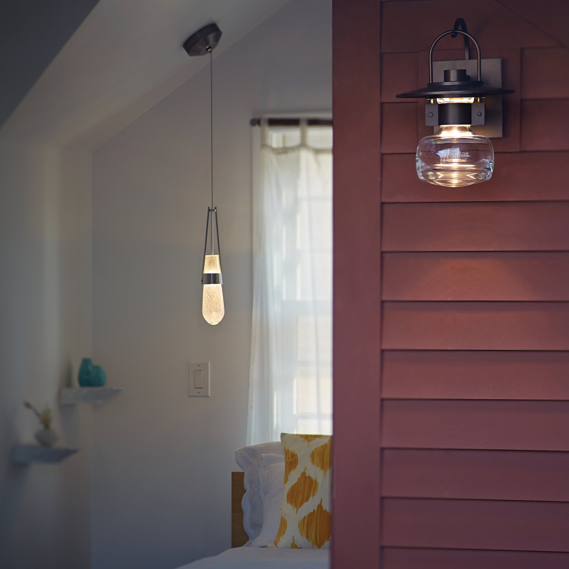 American-made wood furniture is featured in a bright room accented by a hand-blown glass pendant, blending craftsmanship and timeless design.
