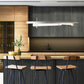 Three Vermont Woods Studios oak bar stools at a light wood island, showcasing quality American-made furniture in a modern kitchen setting.