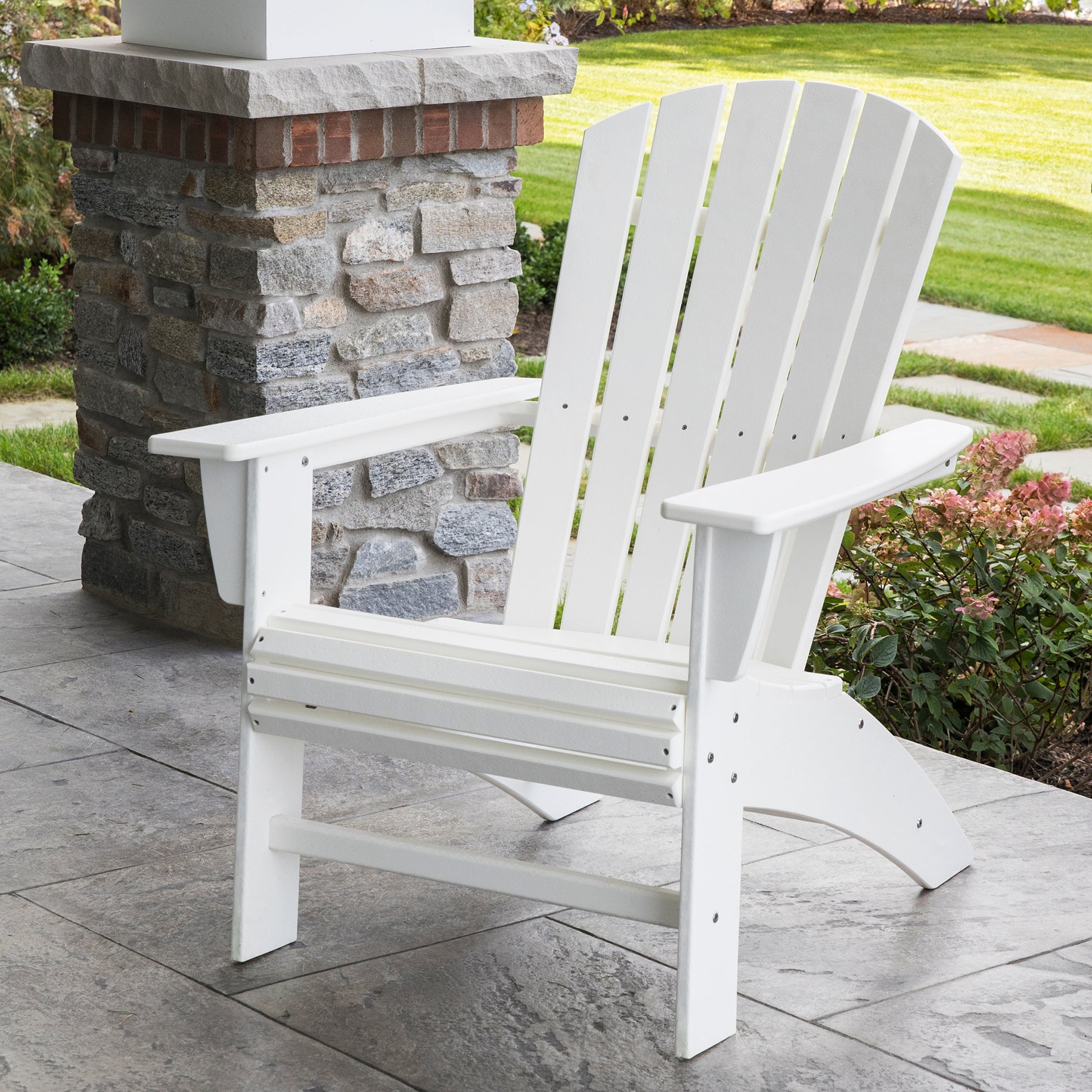 White POLYWOOD Nautical Curveback Adirondack Chair displayed on a patio.