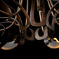 Curved, hand-forged steel arms and bronze detailing on the Parasol 7-Light Chandelier by Hubbardton Forge, showcasing its elegant craftsmanship.