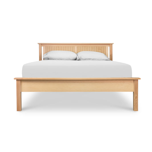Rockingham Bed by Vermont Woods Studios with a distinctive slatted headboard, shown with crisp white bedding and two matching pillows.
