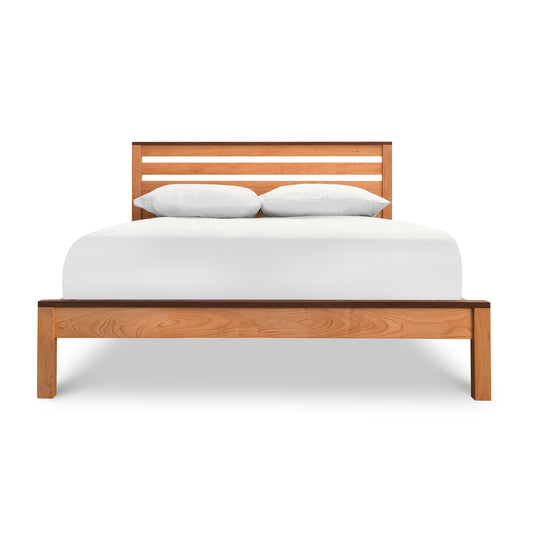 Queen Vermont Furniture Designs Skyline Panel Bed in natural cherry wood with white bedding and pillows, showcasing fine American craftsmanship.