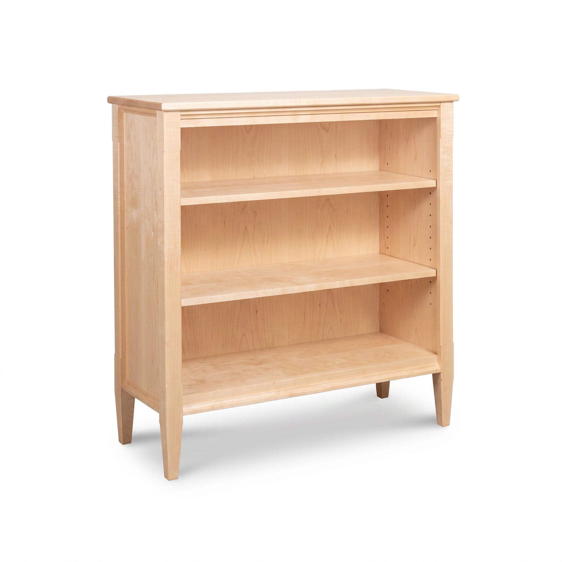 Vermont Shaker Bookcase from Maple Corner Woodworks with three adjustable shelves and four legs, crafted from sustainable hardwoods.