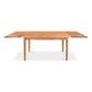 Vermont Shaker Harvest Extension Dining Table by Maple Corner Woodworks, handcrafted from solid wood with elegant tapered legs, shown as a display model.