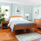 Sustainable Vermont Shaker Moon Bed by Maple Corner Woodworks with blue bedding, part of the elegant Vermont Shaker Furniture Collection.