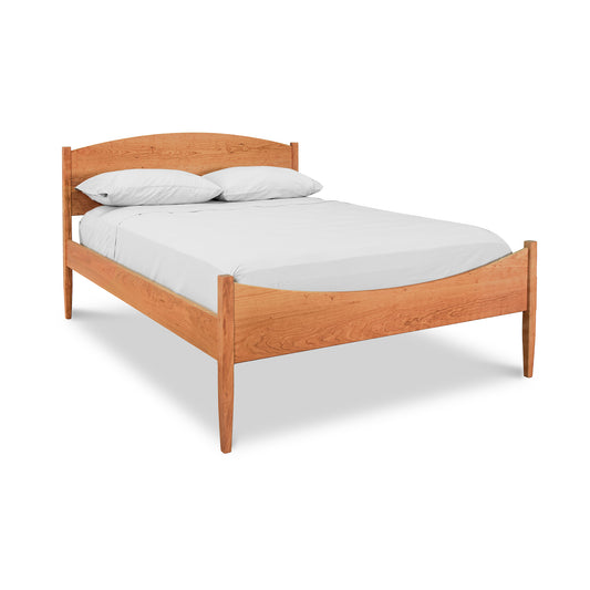 Vermont Shaker Moon Bed by Maple Corner Woodworks with minimalist design and natural wood finish, featuring a white mattress and two pillows.