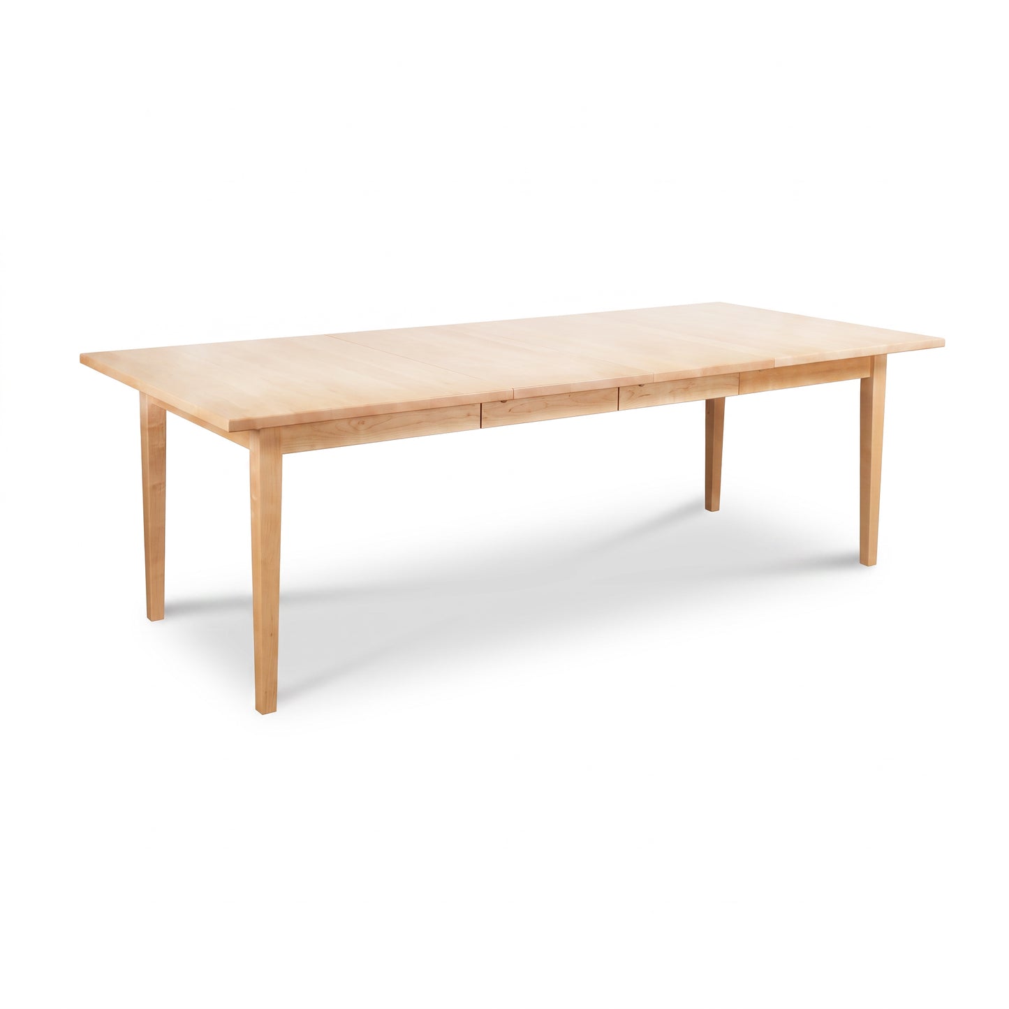 Vermont Shaker Rectangular Extension Dining Table by Maple Corner Woodworks in solid wood with four straight legs and a light natural finish.