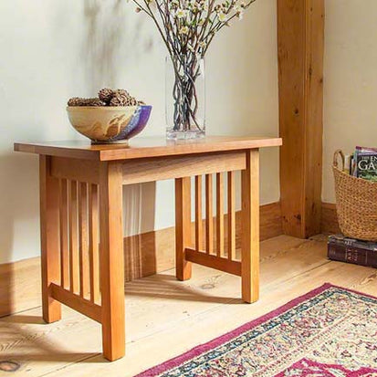 A wooden table with a vase on it.