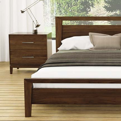 A bedroom with a wooden bed and dresser.