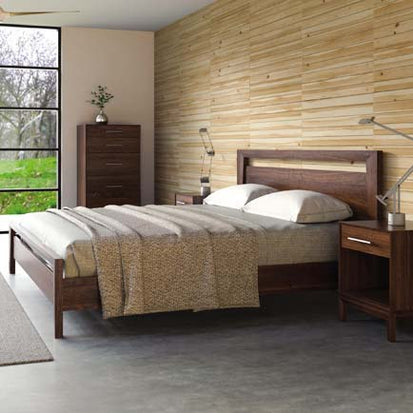 A bedroom with a bed, dresser and nightstand.